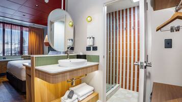 A modern bathroom with a sink, mirror, and shower.