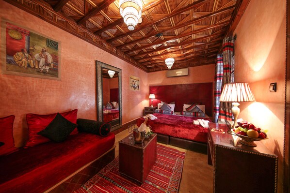 A room with a red sofa, a wooden ceiling, a mirror, and a bed with red bedding. - Riad Africa (Marrakech)