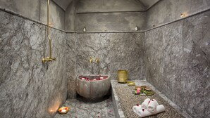 A marble bathroom with a freestanding bathtub, a showerhead, and a towel rack. - Riad Africa (Marrakech)