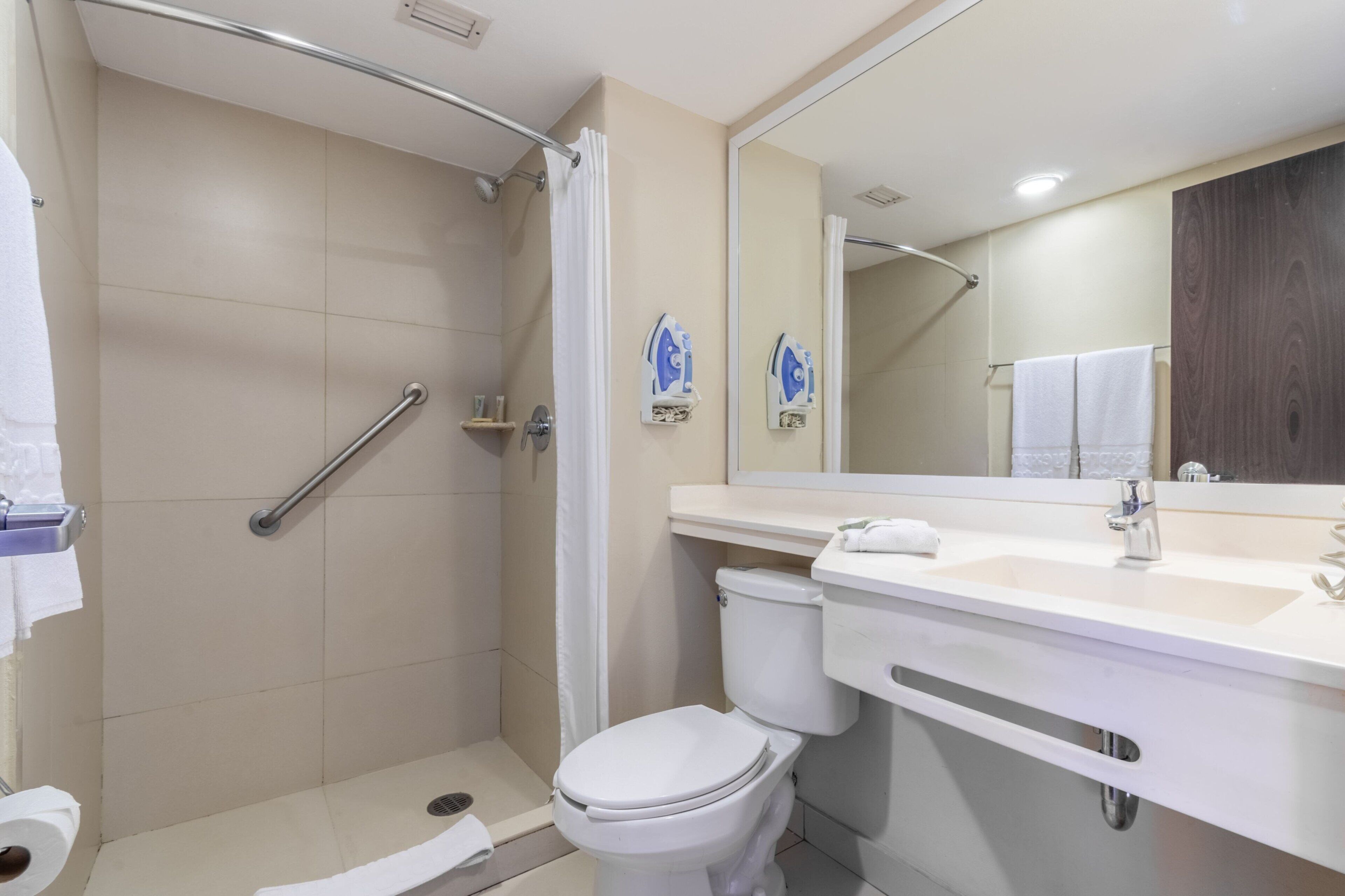 A modern bathroom with a shower, toilet, and sink.