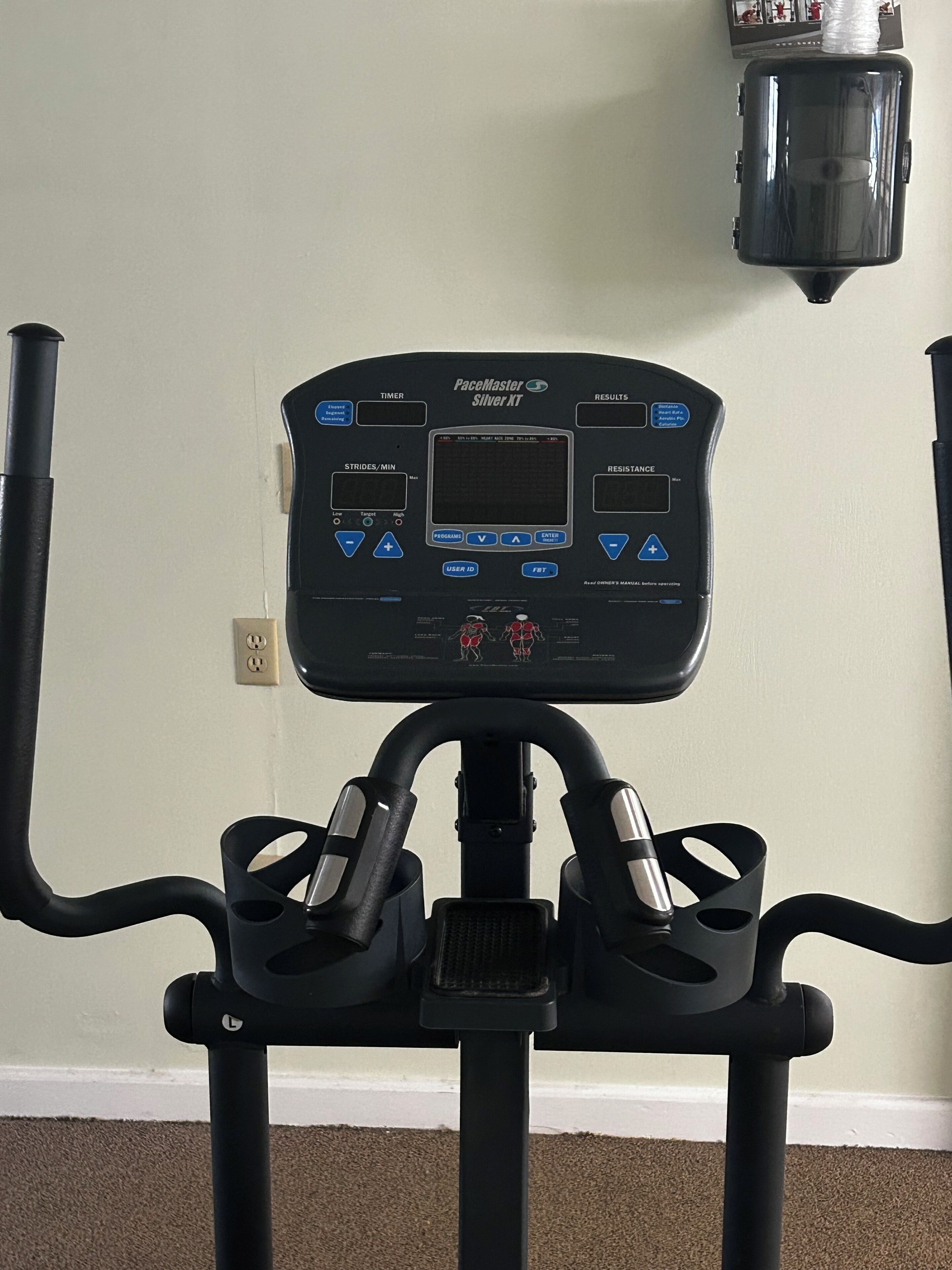 A stationary bike with a digital display, control buttons, and a handlebar.
