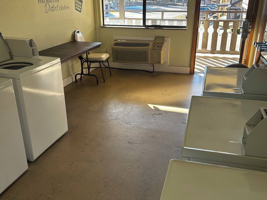 A laundry room with a table, chairs, and a wall-mounted drying rack.
