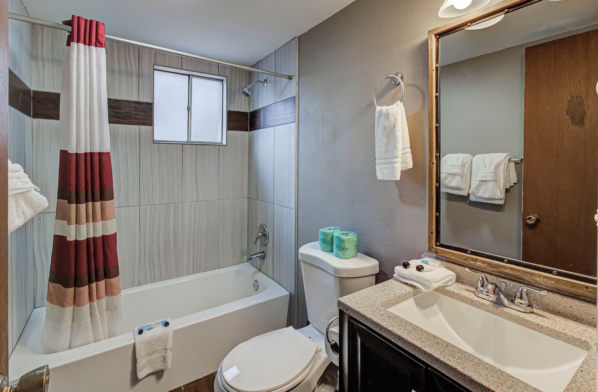 Un baño con bañera, inodoro, lavabo y espejo.
