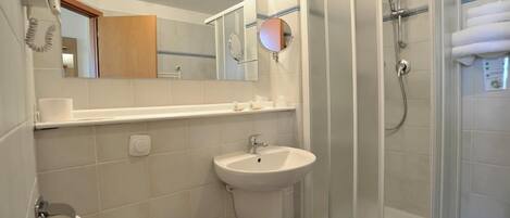 Une salle de bain avec des toilettes, un lavabo et une douche.