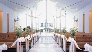 A church interior with pews, a polished floor, and floral arrangements. - Hotel Crown Palais Kitakyushu (Kitakyushu)