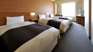 A hotel room with three beds, a television, and a desk with a lamp. - Hotel Crown Palais Kitakyushu (Kitakyushu)