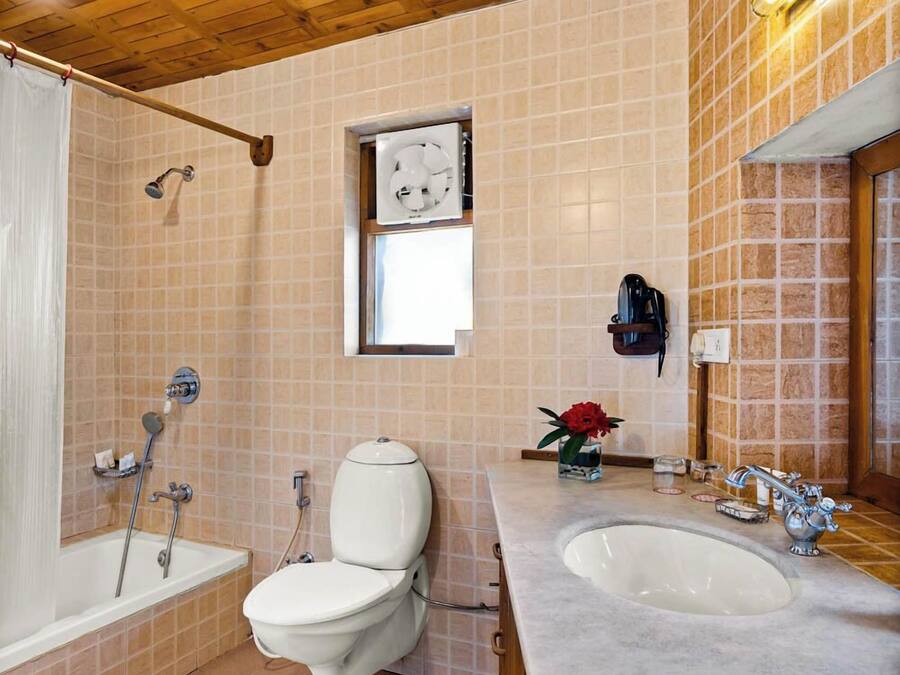 A bathroom with a wooden ceiling, a bathtub, a toilet, and a sink.