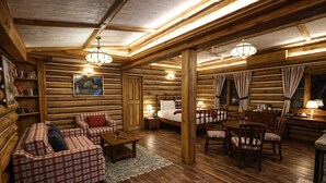 A log cabin interior with a cozy living area, a dining table, and a bedroom. - Rokeby Manor (Mussoorie)