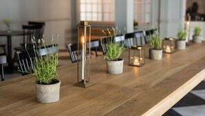 A long wooden table with potted plants and candle holders in a modern interior setting. - The Litchfield Inn (Litchfield)