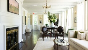 A spacious living room with a fireplace, a dining area, and a sofa. - The Litchfield Inn (Litchfield)