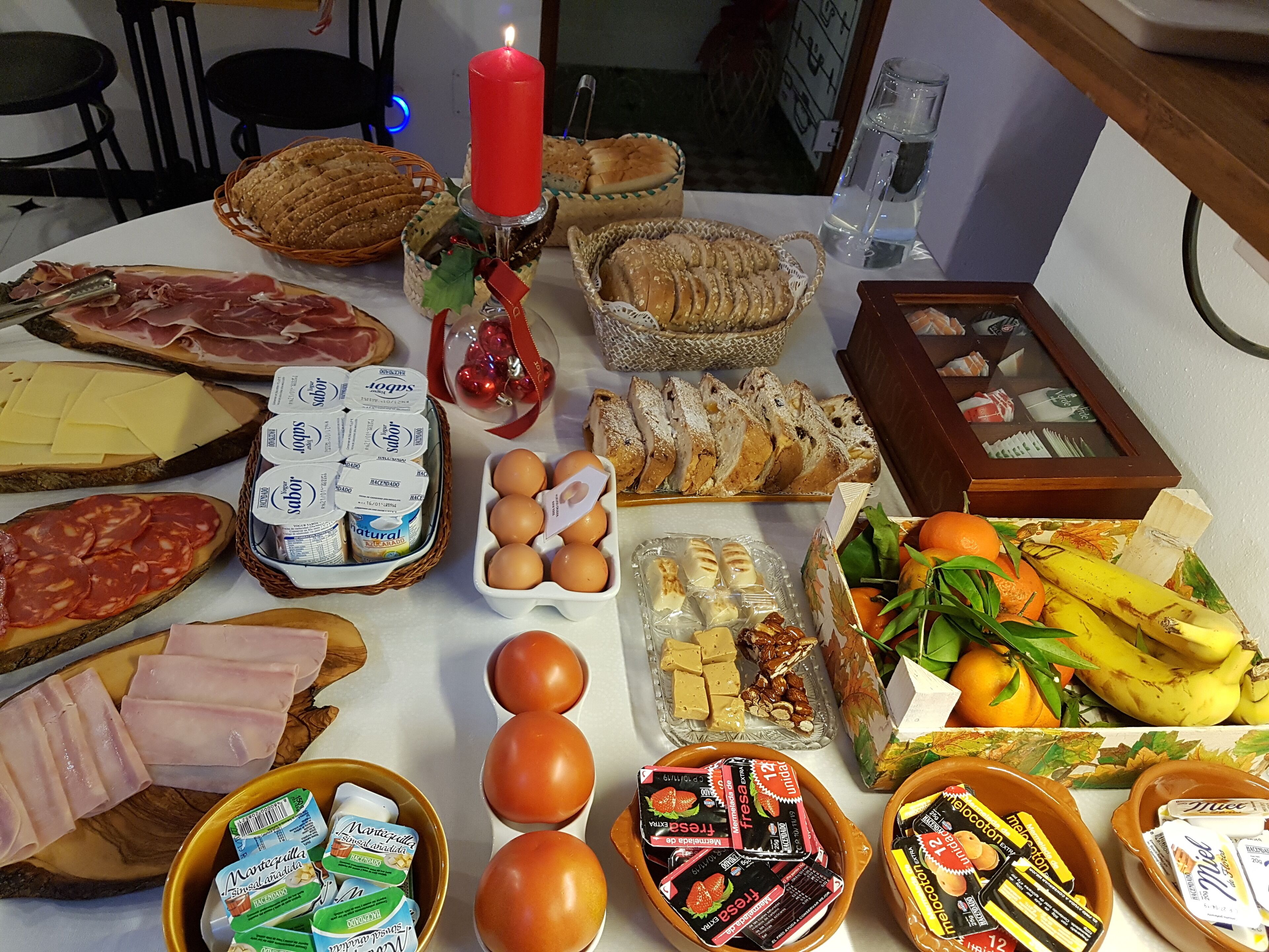 Una mesa con diversos alimentos, como pan, queso, huevos y frutas.