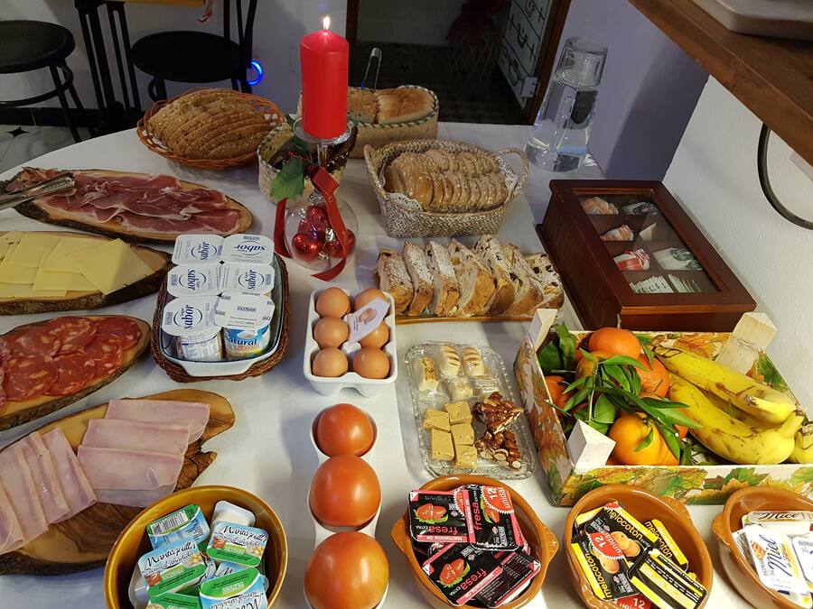Una mesa con diversos alimentos, como pan, queso, huevos y frutas.