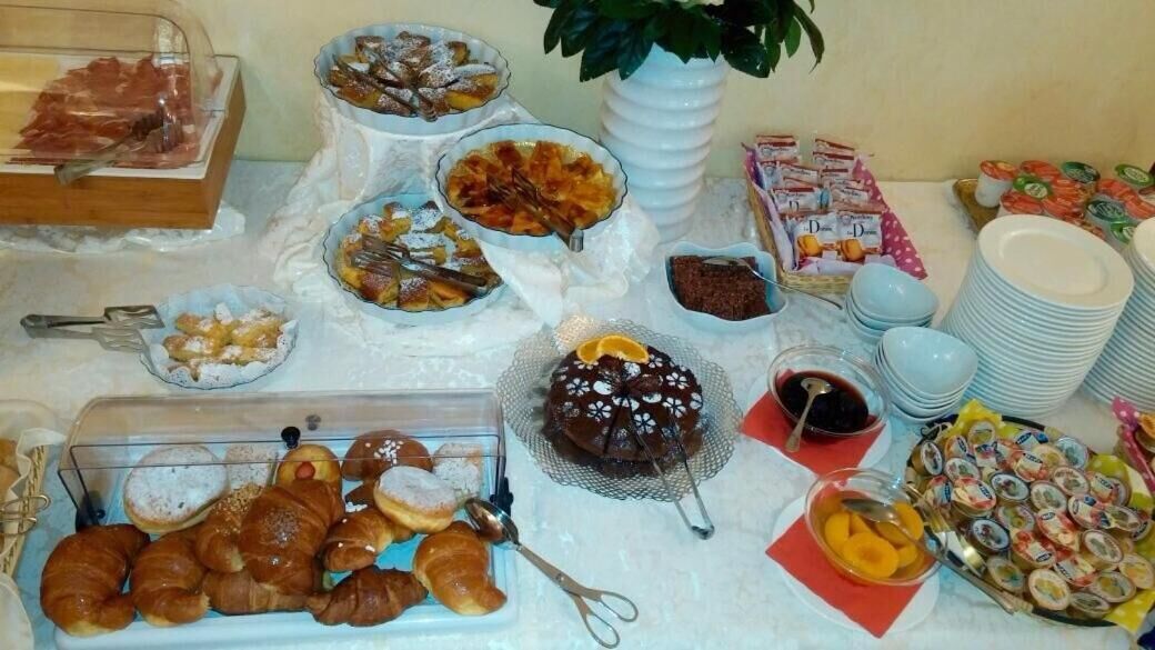 Un bufé con diversas opciones de comida, incluyendo pasteles, postres y bebidas.