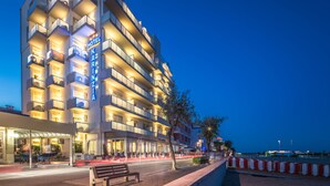 Et hotel med flere etager, altaner og en restaurant i stueplan.