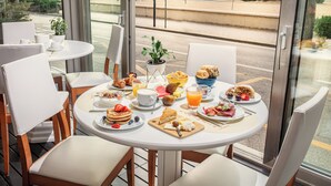 Et morgenbord med et bord, stole og udsigt til gaden.