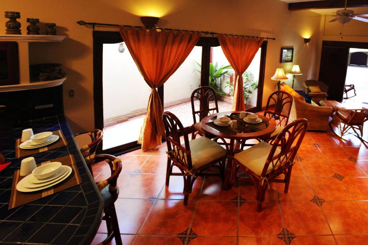 A dining area with a round table, chairs, and a bar counter.