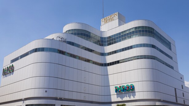 A modern building with a curved facade, featuring the CRESTON HOTEL and PARCO signs. - Chofu Creston Hotel (Chofu)