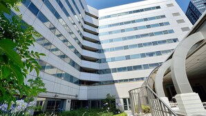 A modern building with a curved facade, large windows, and a staircase leading to an upper level. - Crowne Plaza - ANA Hamamatsu by IHG (Hamamatsu)