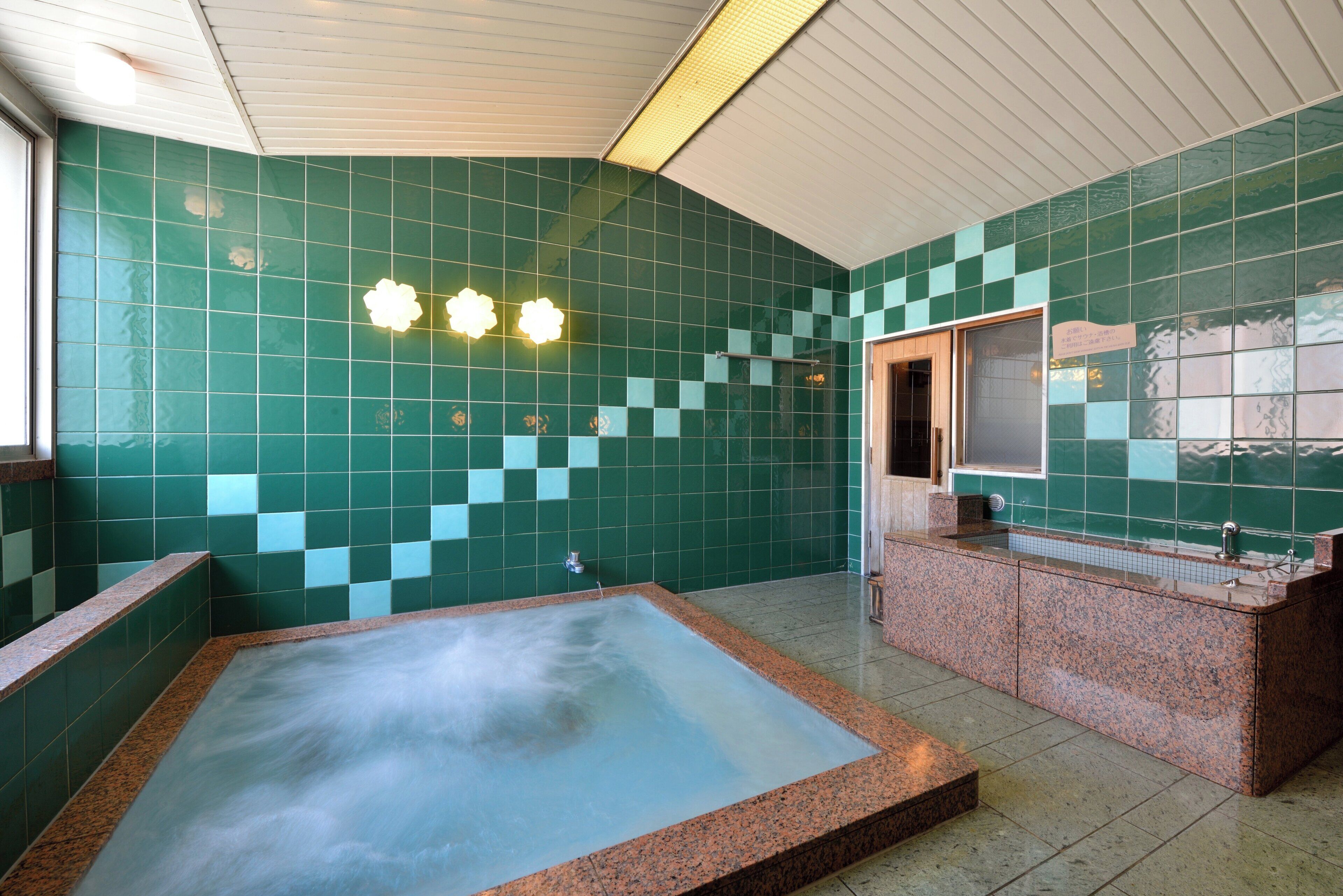 Een badkamer met een groot bad, een wastafel en een spiegel.