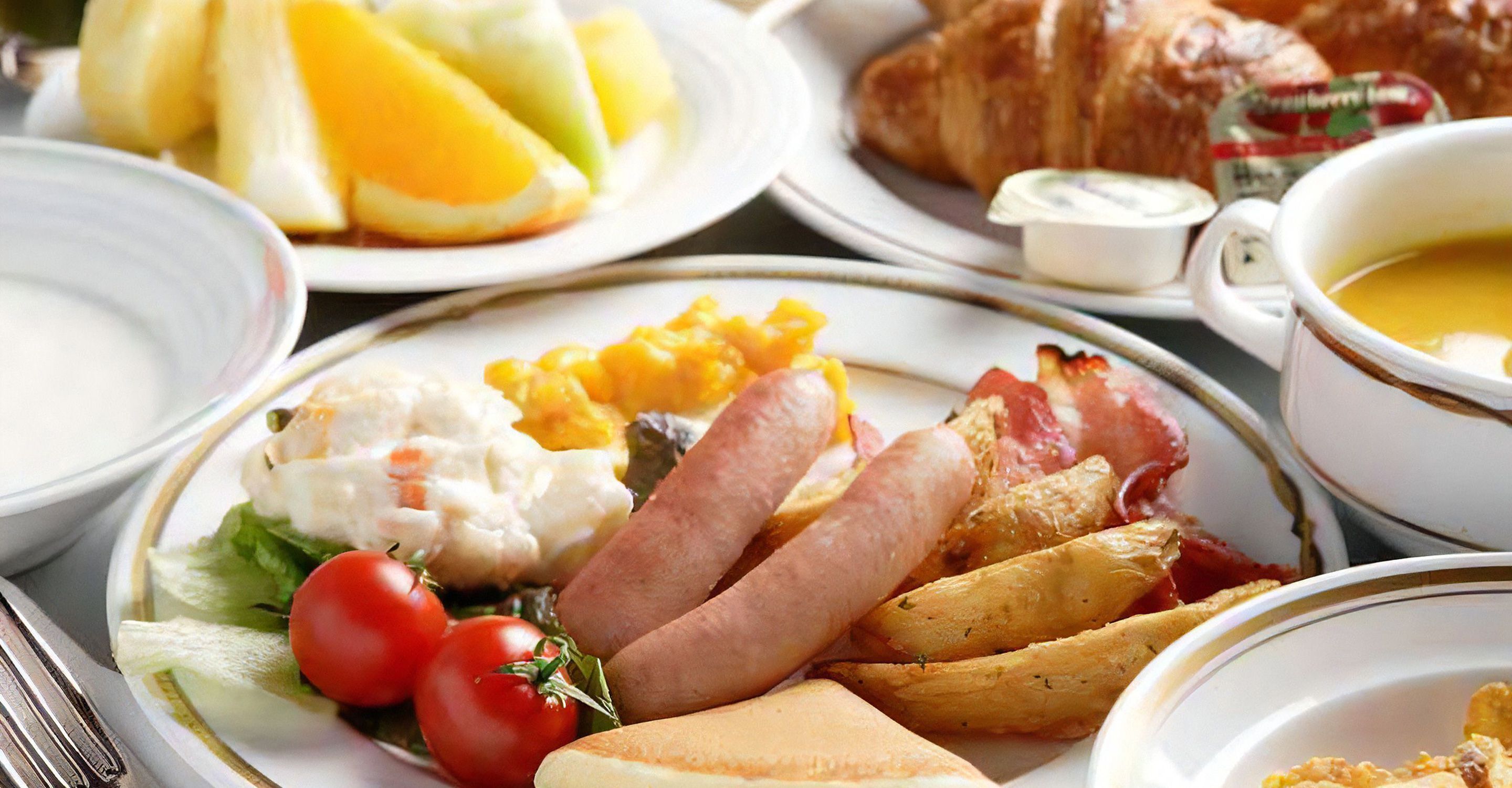 Un copieux petit-déjeuner composé d’œufs, de bacon, de tomates et de pain.