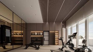 A modern gym with exercise equipment, a wall of dumbbells, and large windows. - Crowne Plaza - ANA Hamamatsu by IHG (Hamamatsu)