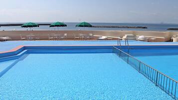 A swimming pool with a view of the beach and ocean.