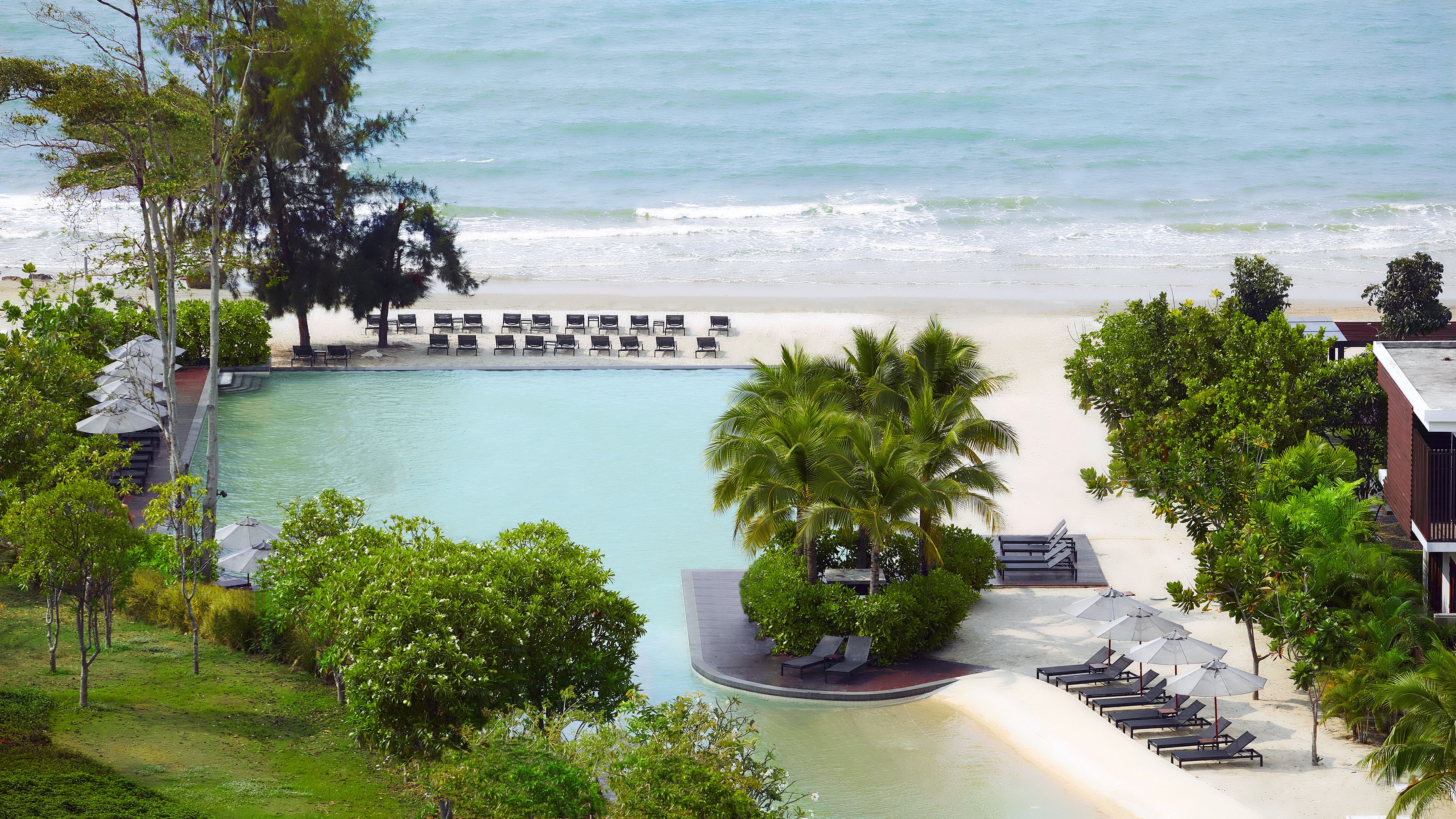 Un resort con piscina, playa y zona de descanso.