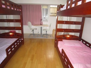 A room with two wooden bunk beds, a small table, and a chair. - Kyoto Catholic House (Kyoto)