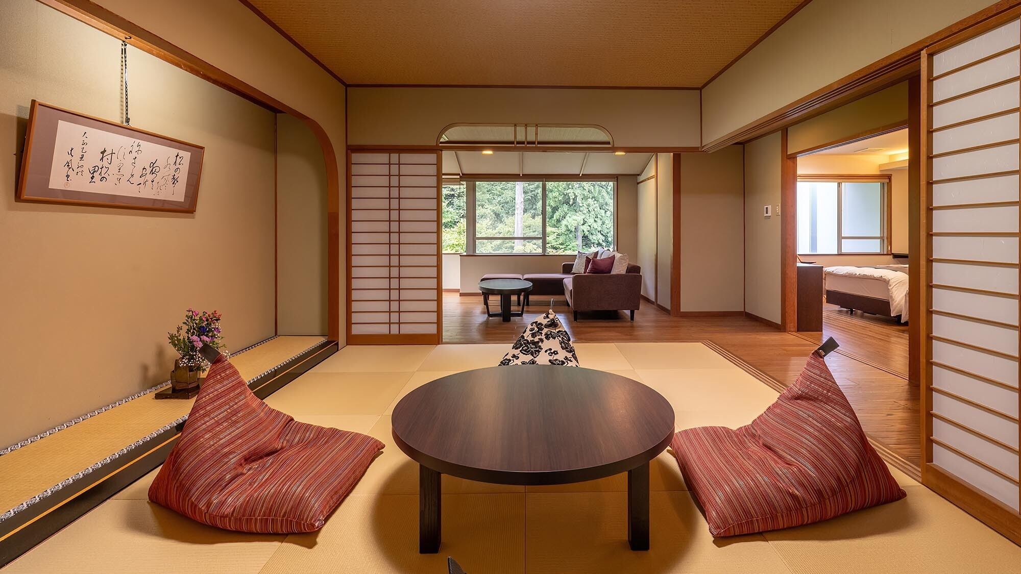 Una habitación japonesa tradicional con suelo de tatami, una mesa baja, cojines y puertas correderas.