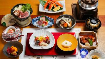 Variedad de platos japoneses dispuestos sobre una mesa de madera, incluyendo sushi, sashimi y otras exquisiteces.