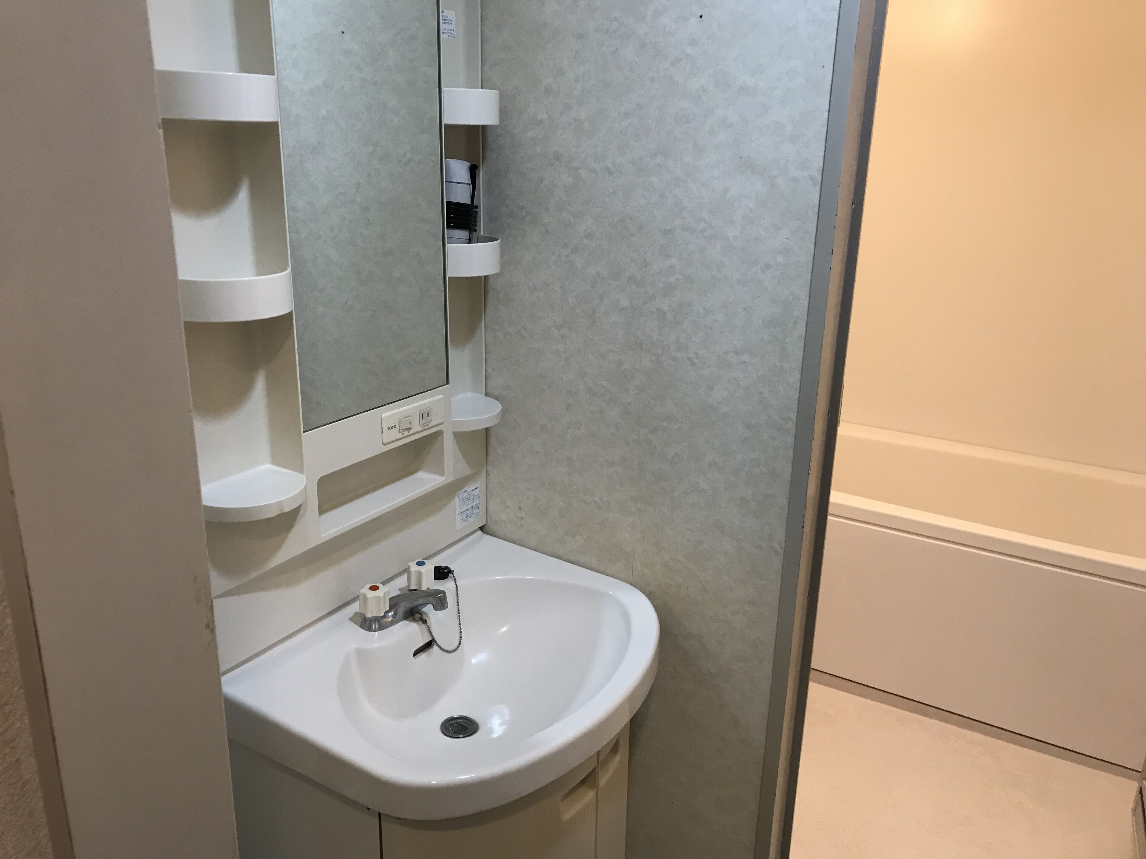 A bathroom with a white sink, a mirror, and a towel rack.