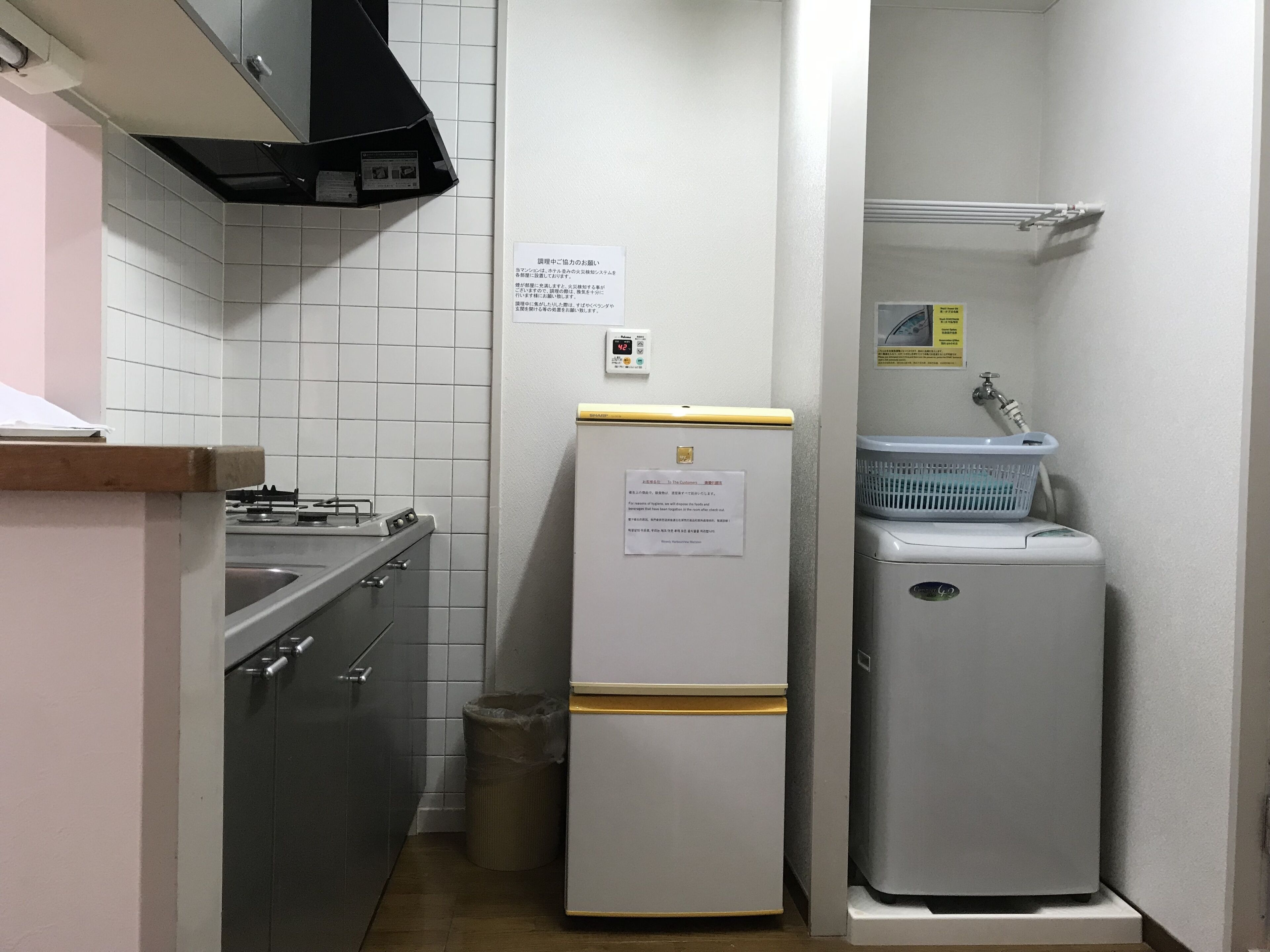 A compact kitchen with a stove, sink, and a refrigerator.