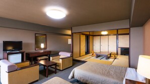 A hotel room with a bed, a desk, a chair, a television, and a traditional Japanese-style room divider. - Hotel Kirishima Castle (Kirishima)