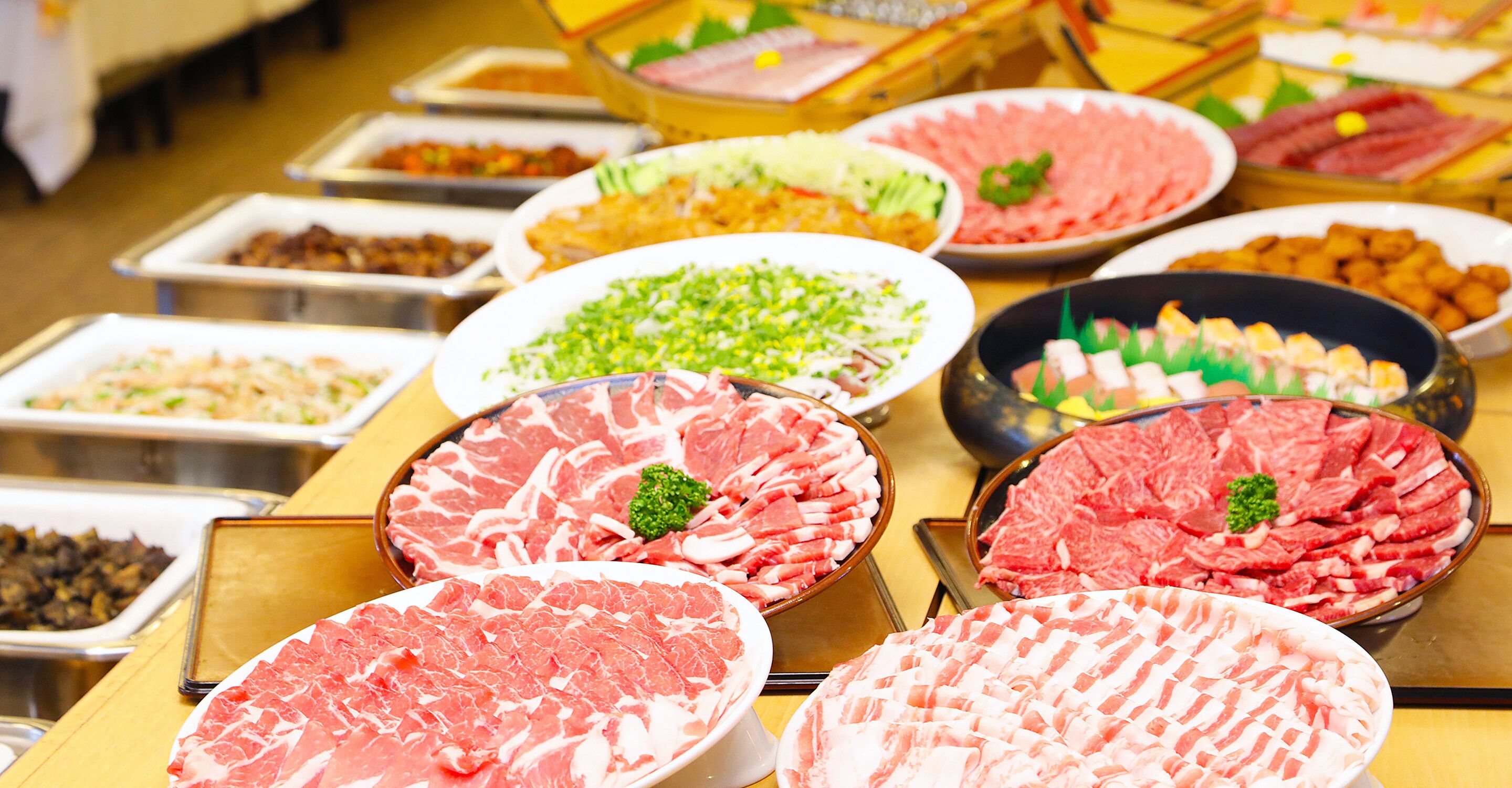 A buffet with various meat dishes and garnishes.