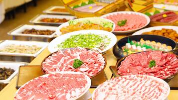 A buffet with various meat dishes and garnishes.