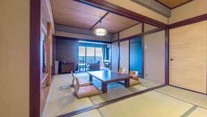 A traditional Japanese room with tatami flooring, a low table, and sliding doors. - Hotel Kirishima Castle (Kirishima)