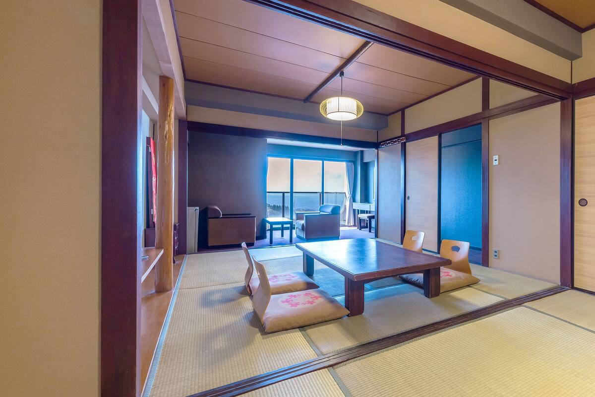 A traditional Japanese room with tatami flooring, a low table, and sliding doors.