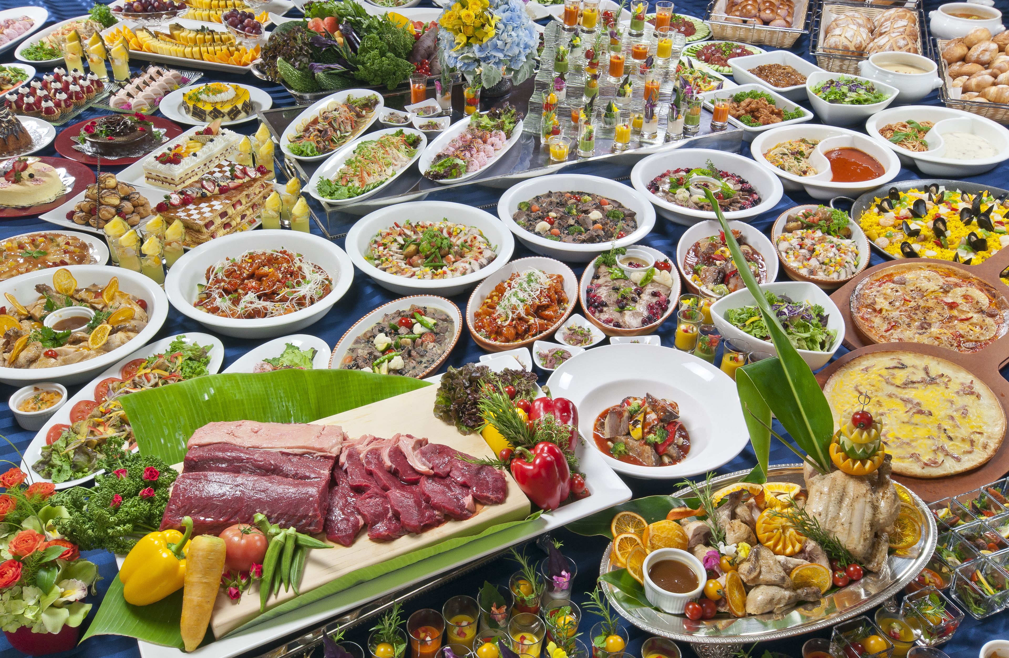 A buffet with a variety of dishes including meats, salads, and desserts.