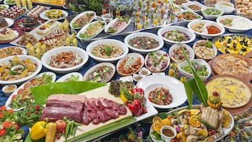 A buffet with a variety of dishes including meats, salads, and desserts.