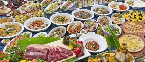 A buffet with a variety of dishes including meats, salads, and desserts.