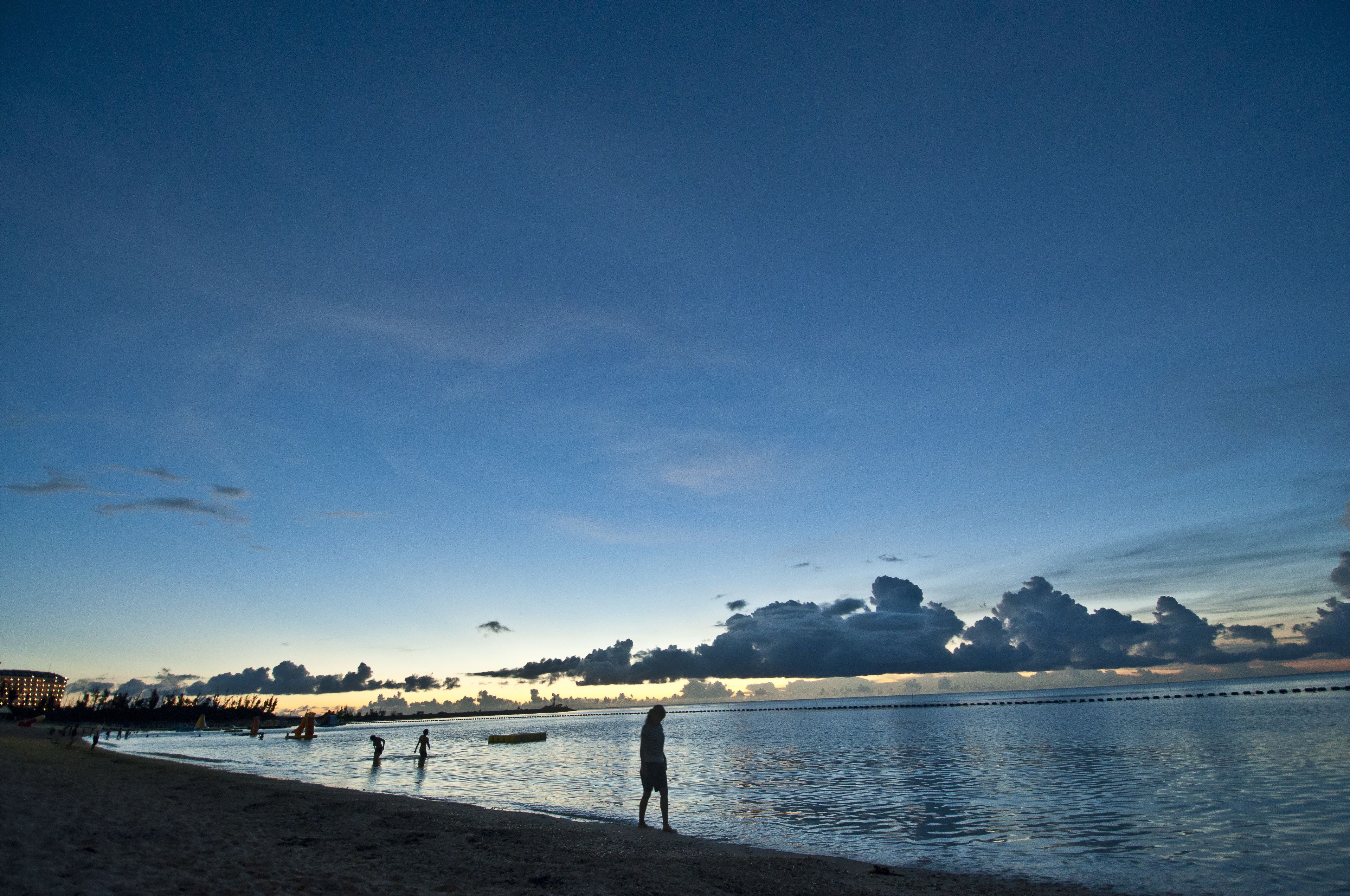 A beach with people and a boat.