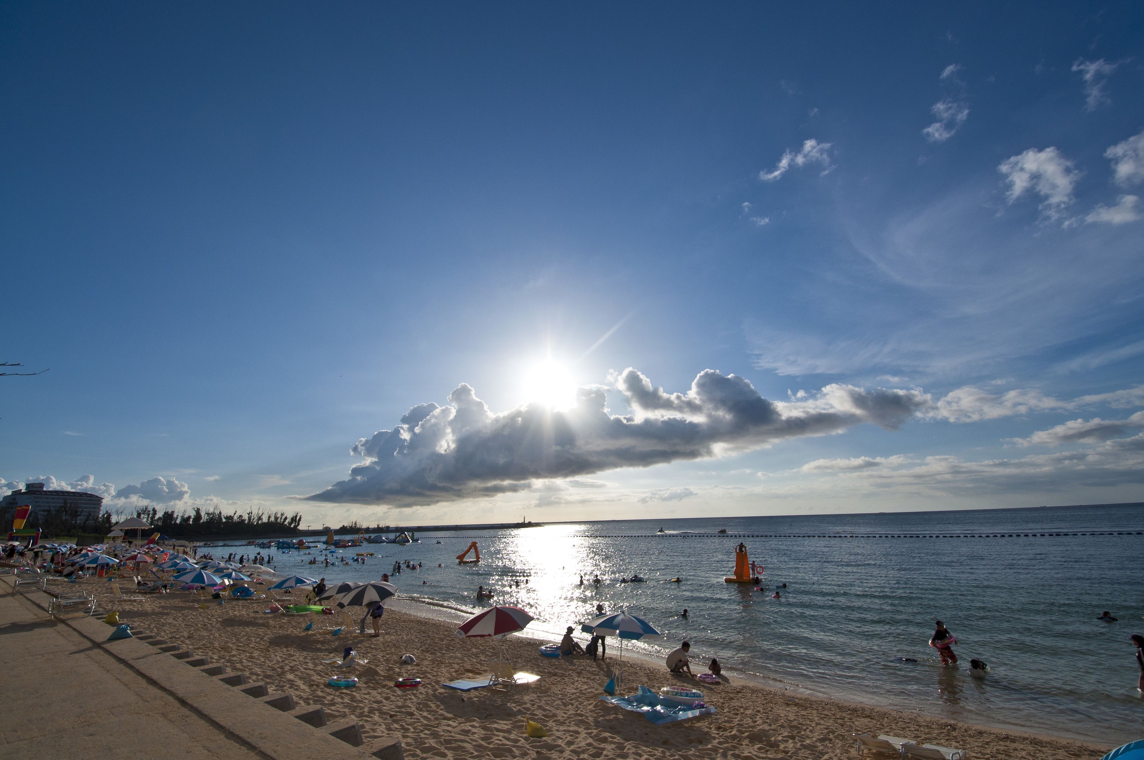 Ein Strand mit badenden, sonnenden und spielenden Menschen.
