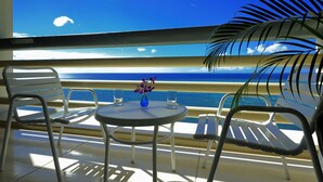 A balcony with a table, chairs, and a vase of flowers. - Rizzan Sea Park Hotel Tancha Bay (Onna)