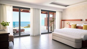 Een moderne hotelkamer met een groot bed, een bureau en uitzicht op de oceaan door middel van kamerhoge ramen.