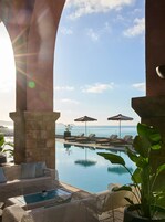 Una piscina techada, una piscina al aire libre, sombrillas