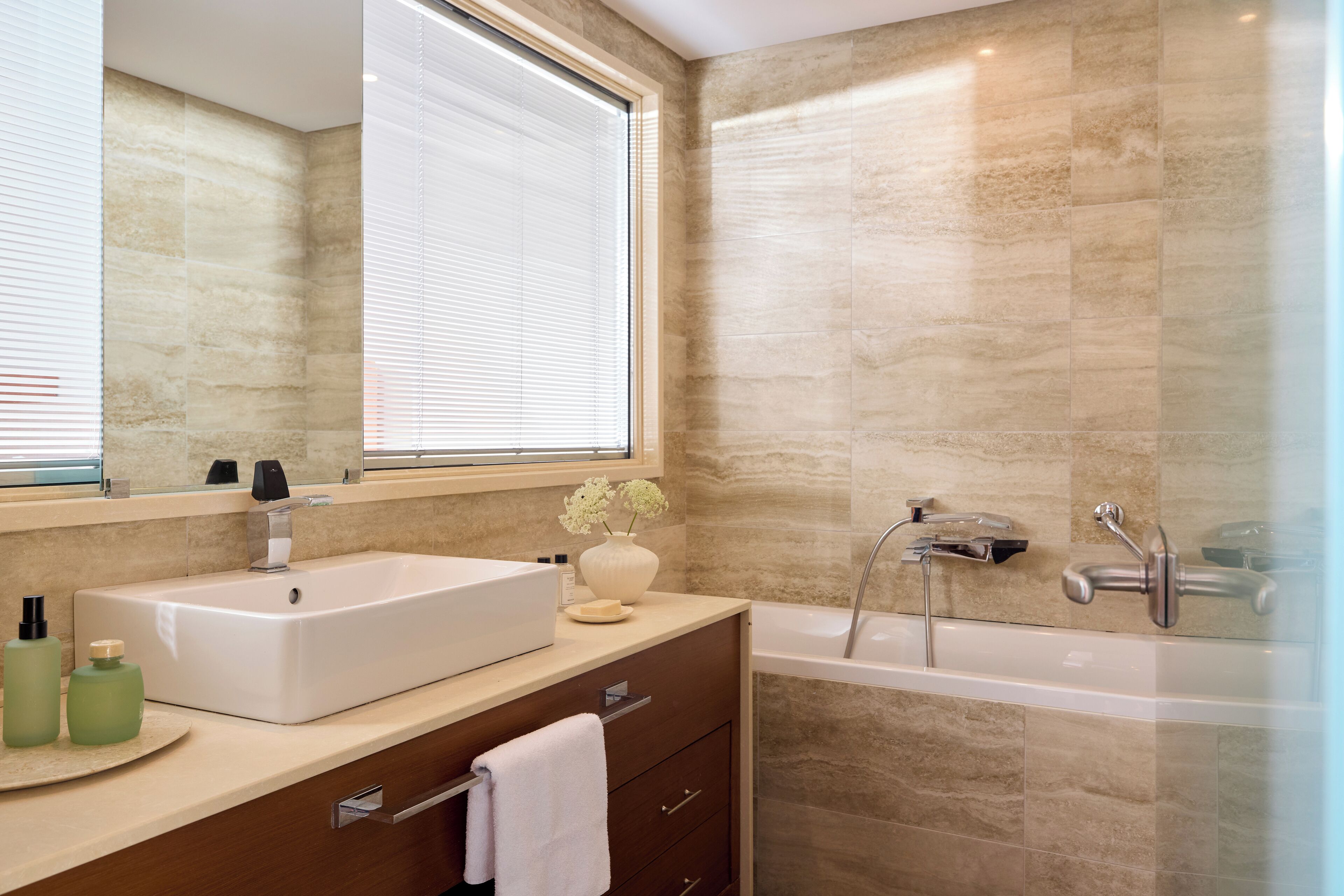 Ein modernes Badezimmer mit einem großen Waschbecken, einem Spiegel und einer Badewanne.