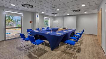 A conference room with a large table, blue chairs, and a whiteboard.