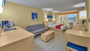 A hotel room with a bed, sofa, coffee table, and a desk with a sink. - City Express by Marriott Campeche (Campeche)