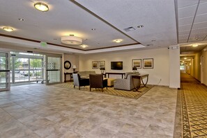 A lobby with a reception desk, seating area, and a patterned carpet.