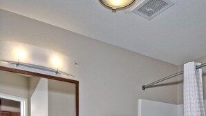 Ein Badezimmer mit Waschbecken, Spiegel, Toilette und Dusche.